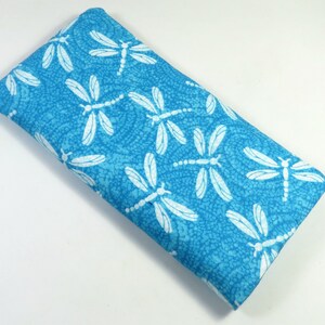 May include: A blue fabric eye mask with a white dragonfly pattern.