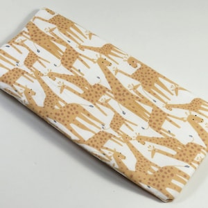 May include: White fabric with a repeating pattern of brown giraffes. The giraffes are illustrated in a simple, cartoon style.