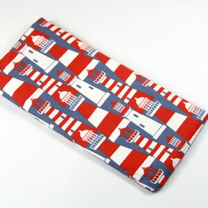 May include: A red and white striped fabric pouch with a lighthouse pattern. The pouch is made of a soft, durable material and is perfect for storing small items.