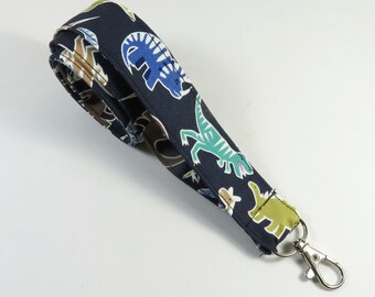 May include: A dark blue lanyard with a colorful dinosaur print and a silver swivel clip.