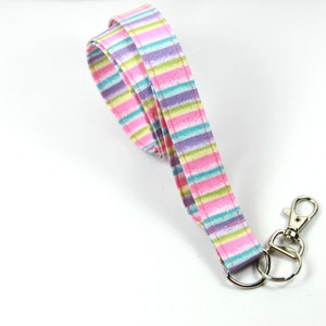May include: A pink, purple, green and blue striped lanyard with a silver swivel clip.
