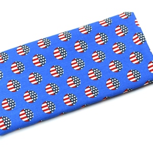 May include: A blue fabric rectangle with a repeating pattern of white circles with red and white stars inside, resembling the American flag.