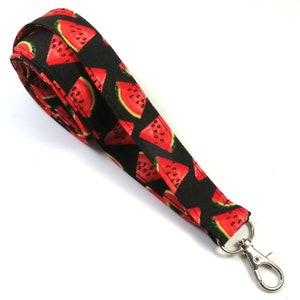 Könnte beinhalten: Ein schwarzes Lanyard mit Wassermelonen-Druck und einem silbernen Drehverschluss.