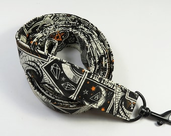 May include: Black and white patterned fabric leash with an orange design and a black metal clip.