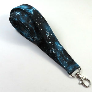 May include: A blue and black galaxy-print lanyard with a silver swivel clip.