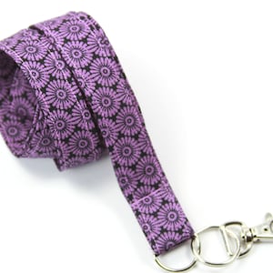 May include: Purple and black patterned lanyard with a silver key ring and clip.