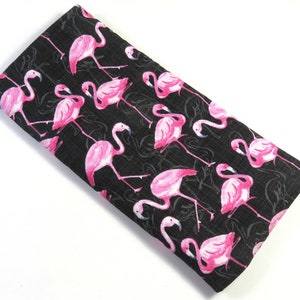 Peut inclure: Tissu noir avec un imprimé de flamants roses. Le tissu est texturé et a un léger brillant.