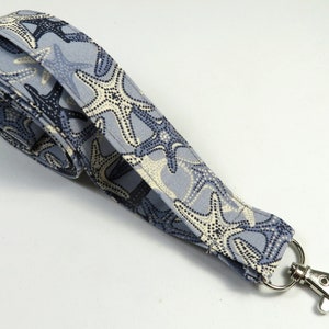 May include: A blue lanyard with a white and blue starfish pattern and a silver swivel clip.