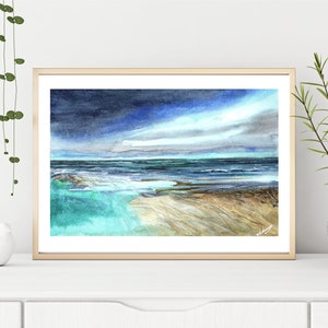 May include: A watercolor painting of a seascape with a stormy sky and turquoise water. The painting is framed in a light wood frame.