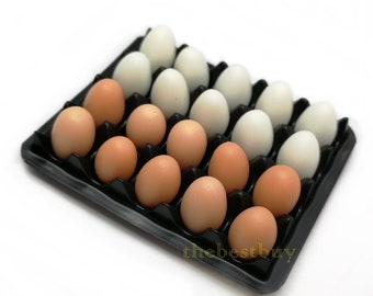 May include: A black plastic egg carton filled with brown and white eggs. The carton has 18 slots, and there are 9 brown eggs and 9 white eggs.