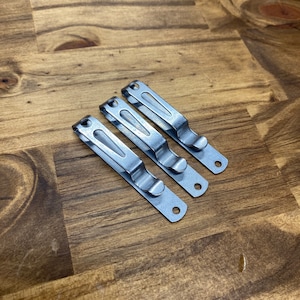 Puede incluir: Tres clips de cintur&oacute;n de metal plateado para sujetar un cuchillo u otras herramientas a un cintur&oacute;n.