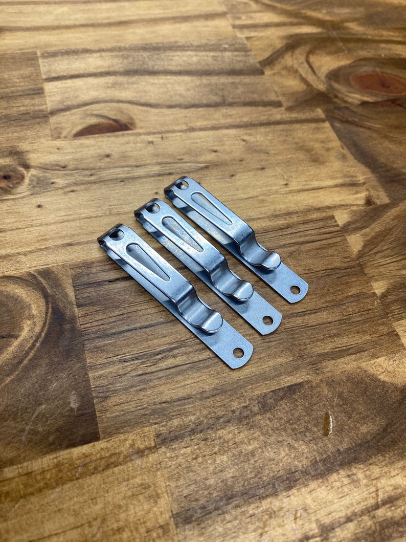 Puede incluir: Tres clips de cintur&oacute;n de metal plateado para sujetar un cuchillo u otras herramientas a un cintur&oacute;n.