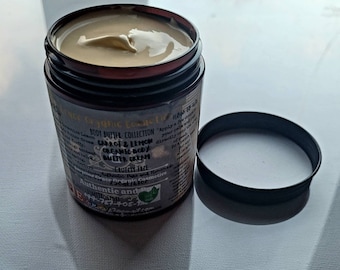 May include: A brown jar with a black lid containing a light yellow body butter. The jar has a label that reads "Body Butter Collection Carrot & Lemon Organic Body Butter Cream Cruelty Free Authentic and Handmade 230ml/8oz".