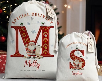 May include: Two off-white canvas drawstring bags featuring red letter graphics, Santa Claus illustrations, and personalized names. The larger bag reads Special Delivery for Molly, and the smaller bag reads Christmas Eve Treats for Sophie.