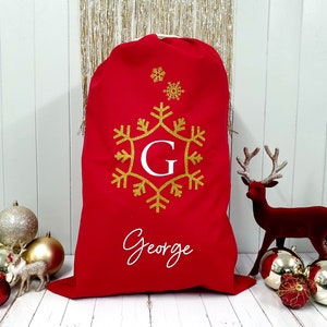 May include: Red Christmas stocking with a gold snowflake design and the name "George" in white lettering.