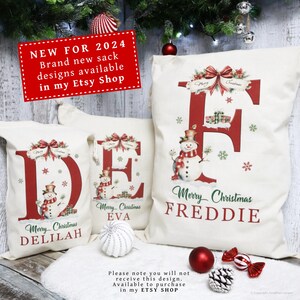 Puede incluir: Tres sacos navide&ntilde;os blancos con letras rojas, mu&ntilde;ecos de nieve y las palabras "Feliz Navidad" y nombres. Los sacos tienen un dise&ntilde;o festivo con lazos y copos de nieve. Un letrero rojo dice "NUEVO PARA 2024".