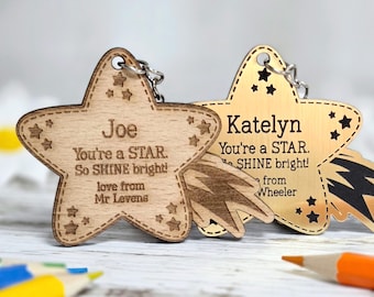 May include: Two star-shaped keychains with metal rings. One is light wood engraved with Joe, You're a STAR. So SHINE bright! love from Mr Levens. The other is gold-toned metal engraved with Katelyn, You're a STAR. So SHINE bright! love from Mr Wheeler.
