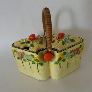 Può includere: Un set vintage in ceramica per zucchero e panna con un manico in legno intrecciato. Il set è decorato con un motivo floreale in tonalità di giallo, rosa, blu e verde. I coperchi hanno accenti rossi.