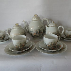 May include: A vintage Japanese tea set featuring a delicate floral design. The set comprises a teapot, creamer, sugar bowl, four cups, and four saucers. The teacups and saucers are decorated with a landscape scene.