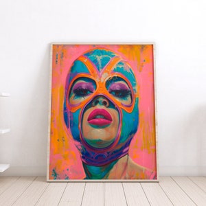 May include: A framed artwork featuring a portrait of a person wearing a colorful wrestling mask. The mask is blue and orange, with pink lips and eye makeup. The background is a vibrant pink and orange, creating a bold and eye-catching piece.