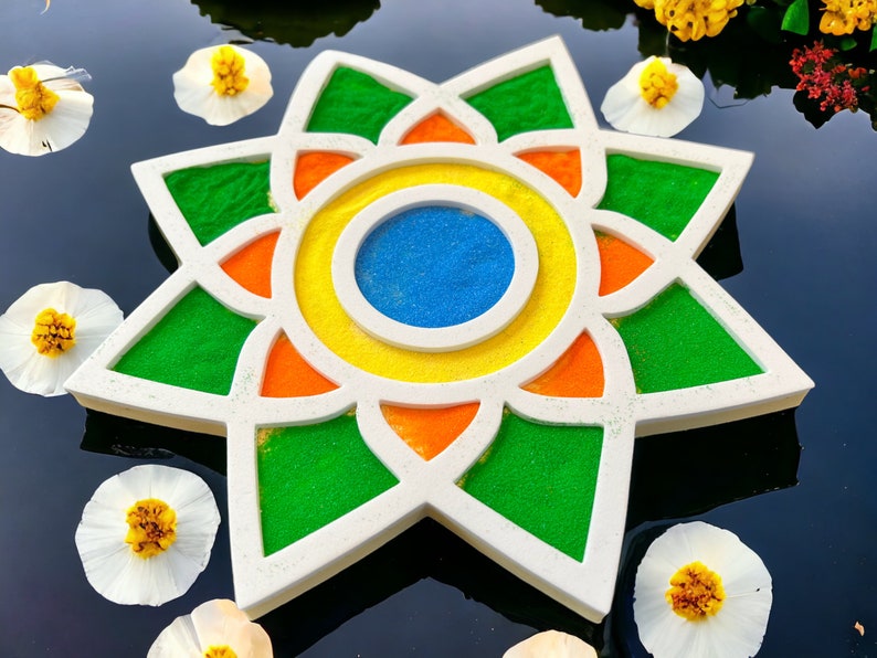 May include: A white star-shaped tray with a colorful mandala design. The mandala features green, orange, yellow, and blue sand.