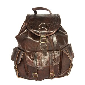 May include: A brown leather backpack with multiple pockets and buckles. The backpack has a flap with a buckle closure and a drawstring closure.