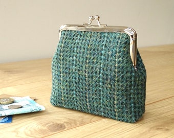 May include: A small green and blue tweed coin purse with a silver clasp.