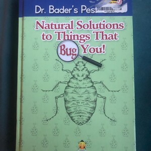 May include: A book titled "Dr. Bader's Pest: Natural Solutions to Things That Bug You!" features a green cover with a large insect illustration and a magnifying glass. The author's name, Dr. Myles H. Bader, is printed at the bottom.