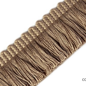 Może przedstawiać: Zbliżenie brązowej frędzli z tkanym brzegiem. Frędzla jest wykonana z miękkiego, naturalnego włókna i ma subtelną fakturę. Tekst "col 5" jest widoczny w prawym dolnym rogu obrazu.