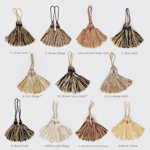 Peut inclure: Assortiment de 11 passementeries à franges de différentes couleurs, notamment le brun, le beige, l'or, le bleu, l'ivoire, le blanc et le noir. Les franges sont en tissu doux et texturé et présentent un design classique et élégant.
