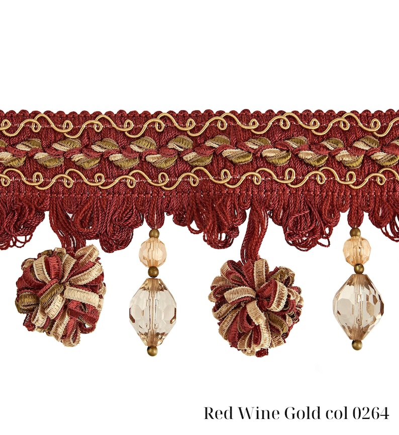 May include: Decorative trim in red wine and gold. The trim features a woven design with gold accents, tassels, and decorative beaded pendants. The text "Red Wine Gold col 0264" is printed at the bottom. This trim is suitable for home decor and craft projects.