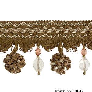 May include: Brown decorative trim with a textured design, featuring a woven top section with a wavy pattern and a fringe of tassels. Clear, faceted beads and pink beads hang from the trim. The text "Brown col 10645" is at the bottom.