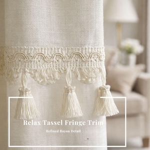 Könnte beinhalten: Cremefarbener Vorhang mit dekorativer Fransenborte mit wellenförmigem Design und hängenden Quasten. Der Text "Relax Tassel Fringe Trim" und "Refined Rayon Detail" ist auf dem Vorhang zu sehen.