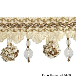 May include: Ecru beige decorative trim with a detailed design. The trim features a woven top section with embroidered leaves and a wavy gold trim. Below, there are hanging tassels, clear faceted beads, and decorative beige and gold accents. The text "Ecru Beige col 0109" is at the bottom.