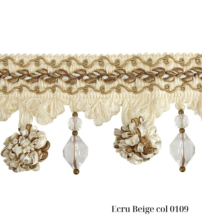 May include: Ecru beige decorative trim with a detailed design. The trim features a woven top section with embroidered leaves and a wavy gold trim. Below, there are hanging tassels, clear faceted beads, and decorative beige and gold accents. The text "Ecru Beige col 0109" is at the bottom.
