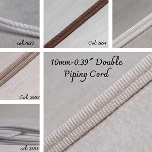Puede incluir: Primer plano de varios cordones de ribete dobles en diferentes colores, incluyendo blanco, marrón y beige. Se muestra el texto "10mm-0.39" Double Piping Cord". Cada cordón mide aproximadamente 1 cm de ancho, adecuado para proyectos de costura y manualidades.