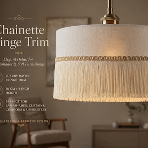 Può includere: Paralume beige con finiture a catenella dorata e frange. Il testo sull'immagine recita "Chainette Fringe Trim" e "Elegant Detail for Lampshades & Soft Furnishings." L'altezza è di 10 cm.