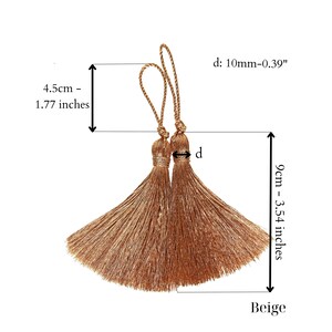 Op de afbeelding: Twee beige zijden kwastjes met een lengte van 4,5 cm en een breedte van 9 cm. De kwastjes hebben een diameter van 10 mm.