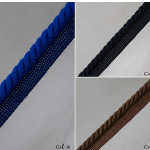 May include: Close-up of three samples of decorative trim. The top sample is a vibrant blue rope trim with a matching blue mesh backing. The middle sample is black rope trim with a black mesh backing. The bottom sample is brown rope trim with a brown mesh backing.
