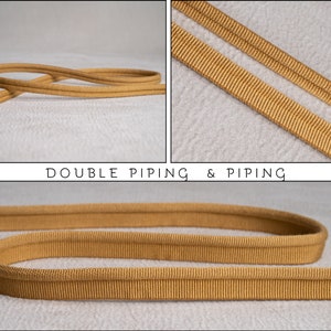 Puede incluir: Primer plano de dos piezas de doble vivo de color dorado. El vivo es un tipo de adorno utilizado en la costura y la artesanía. El texto "DOUBLE PIPING & PIPING" es visible en la imagen.