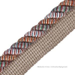 May include: Multicolor 10 mm - 0.39 inches Piping Cord. A close-up of a braided cord with a multi-colored pattern. The cord is woven with a variety of colors, including red, blue, green, and white. The cord is also woven with a beige fabric.