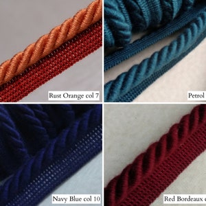May include: Close-up of four samples of decorative rope trim in various colors. The colors include rust orange, petrol blue, navy blue, and red bordeaux. Each trim has a twisted rope design with a woven edge. The text on the image indicates the color names and codes.