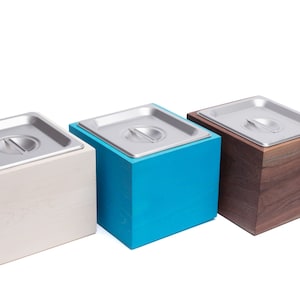 May include: Three square wooden boxes with metal lids. The boxes are in white, blue, and brown.