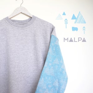 Könnte beinhalten: Ein graues Sweatshirt mit einem blauen, gemusterten Ärmel. Der Ärmel zeigt ein sich wiederholendes Muster aus stilisierten Bäumen. Das Wort "MALPA" ist in Grau auf weißem Hintergrund gedruckt.