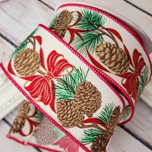 May include: White ribbon with a red trim and a repeating pattern of pine cones, pine branches, and red bows.