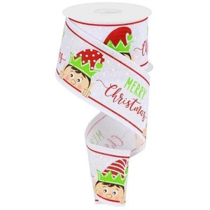 May include: White Christmas ribbon with a repeating pattern of elf faces wearing green and red hats. The ribbon has the words "MERRY Christmas" in red and green. The ribbon is on a white spool.
