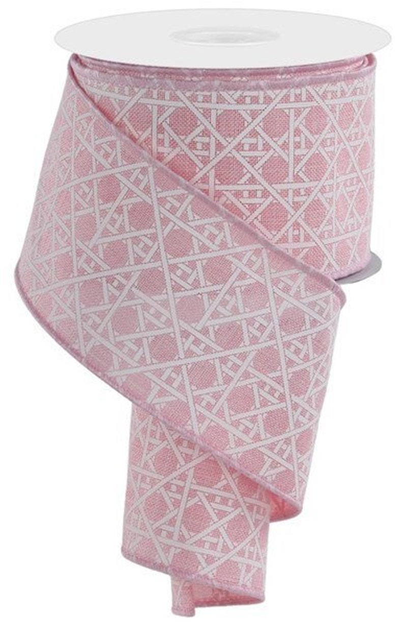 May include: Pink wired ribbon with a white geometric pattern. The ribbon is rolled up on a spool.