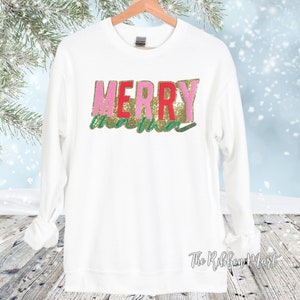 May include: White sweatshirt with the text "Merry" in pink, red, and gold glitter letters and "Christmas" in green glitter letters.