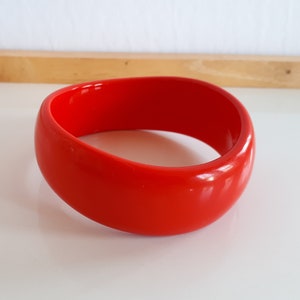 Lebhafter roter Lucit Kunststoff Armreif mit Wellenform