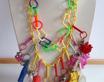collier à breloques en plastique multicolore vintage des années 80 avec 11 énormes breloques figuratives sur une chaîne en lucite jaune à collectionner